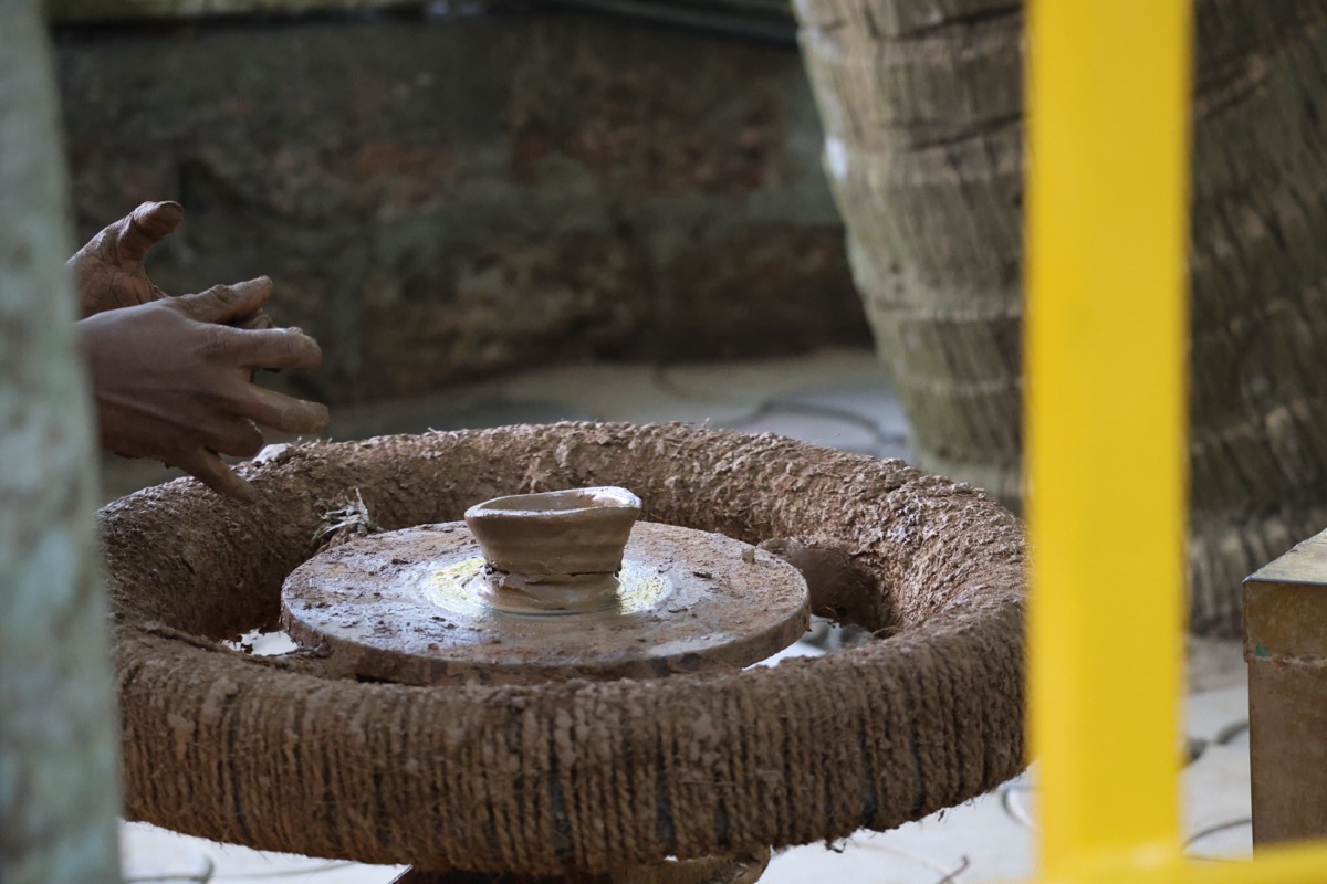 Traditional potter shaping clay on a hand-powered kick wheel in India
